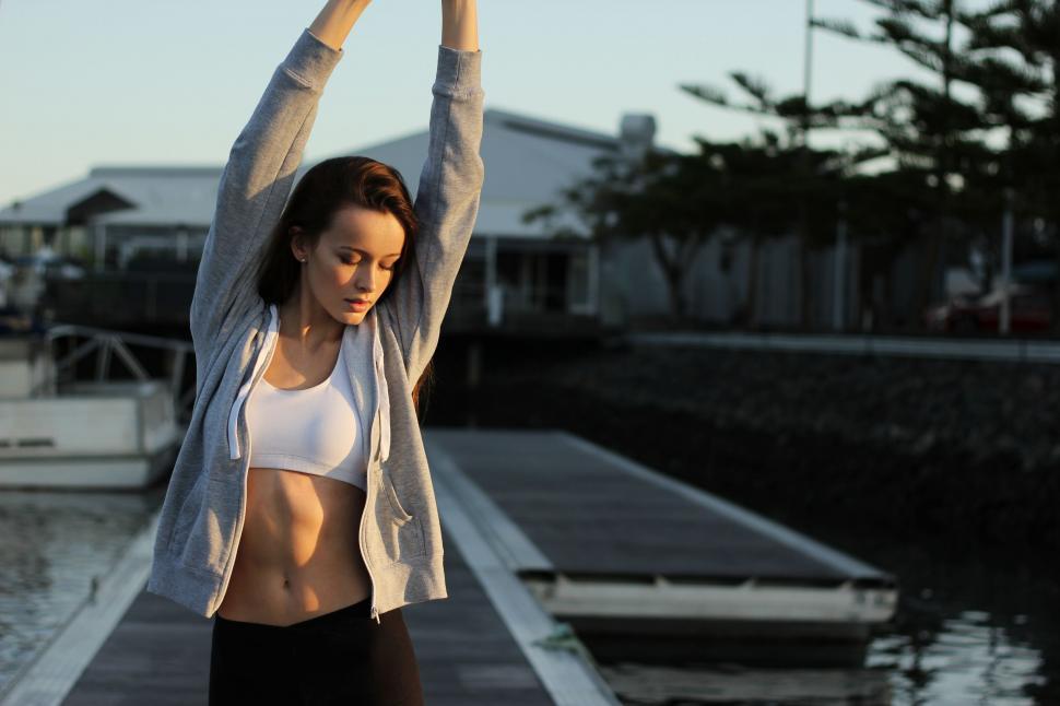 Free Image of Woman Stretching Arms on Dock 