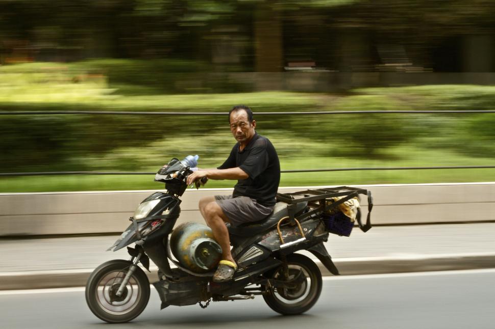 Free Image of Man Riding Motorcycle Down Street 