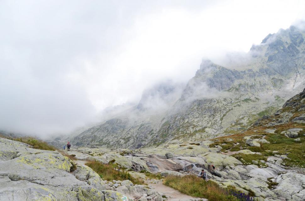 Free Image of Man Hiking Up a Mountain in the Clouds 