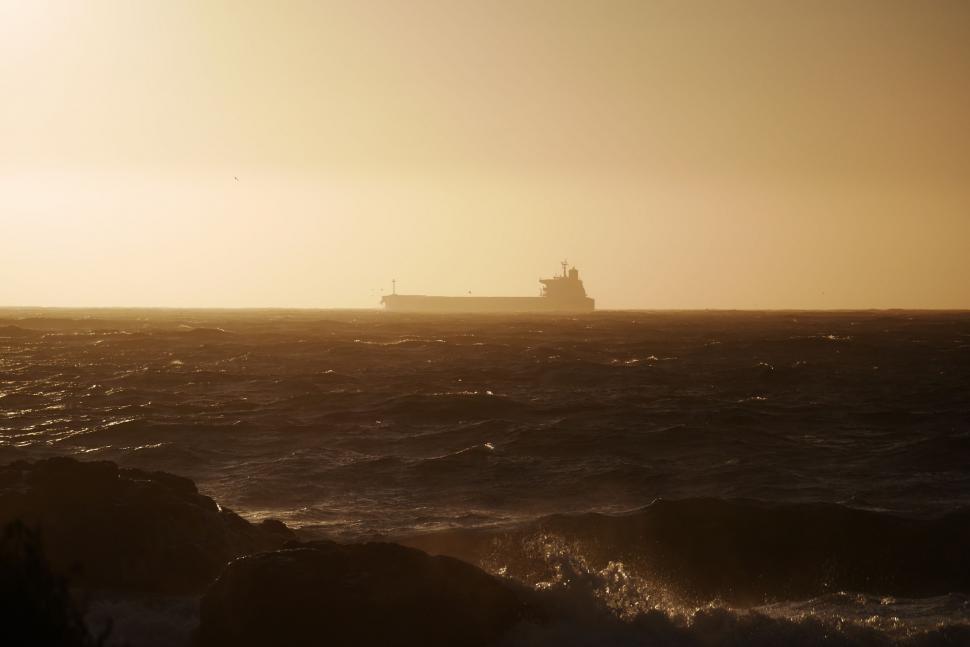 Free Image of Large Boat Sailing in the Ocean at Sunset 
