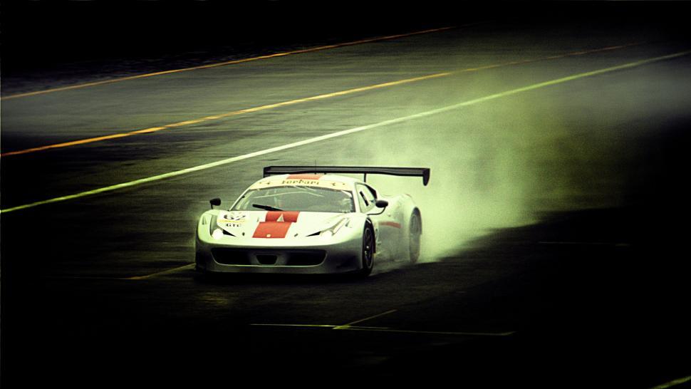 Free Image of White Race Car Driving Down Road at Night 