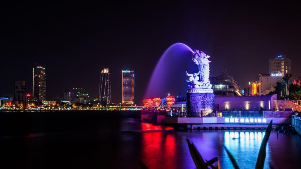 Free Image of Night View of City With Fountain in Foreground 
