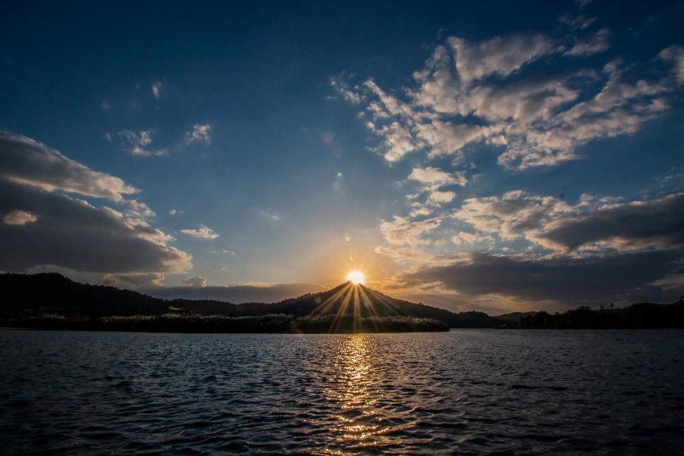 Free Image of Sun Setting Over Lake With Mountains in Background 