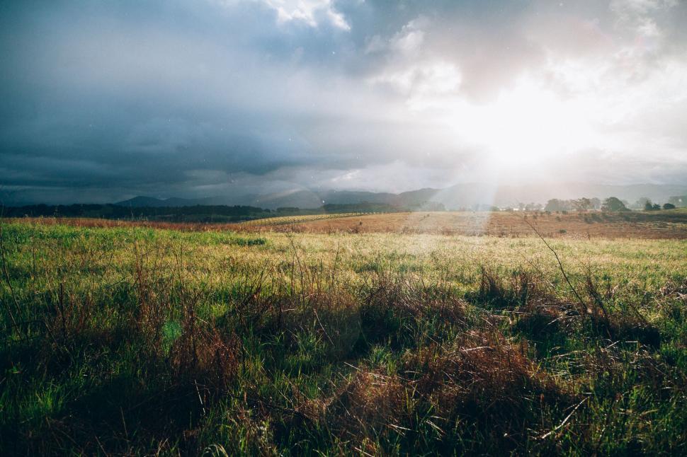 Free Image of Sun Shining Through Clouds Over Field 