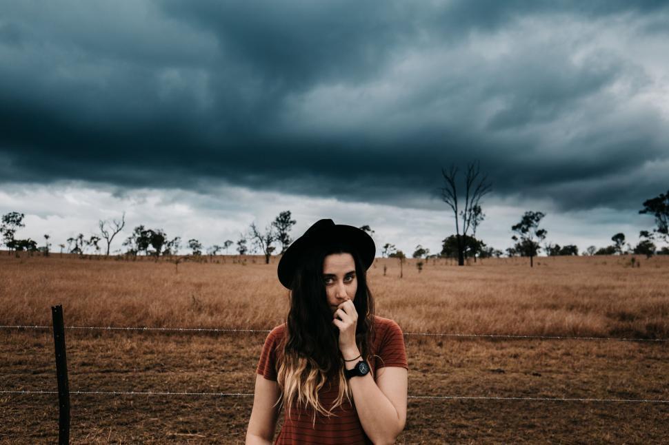 Free Image of Woman Standing in Field With Hat On 