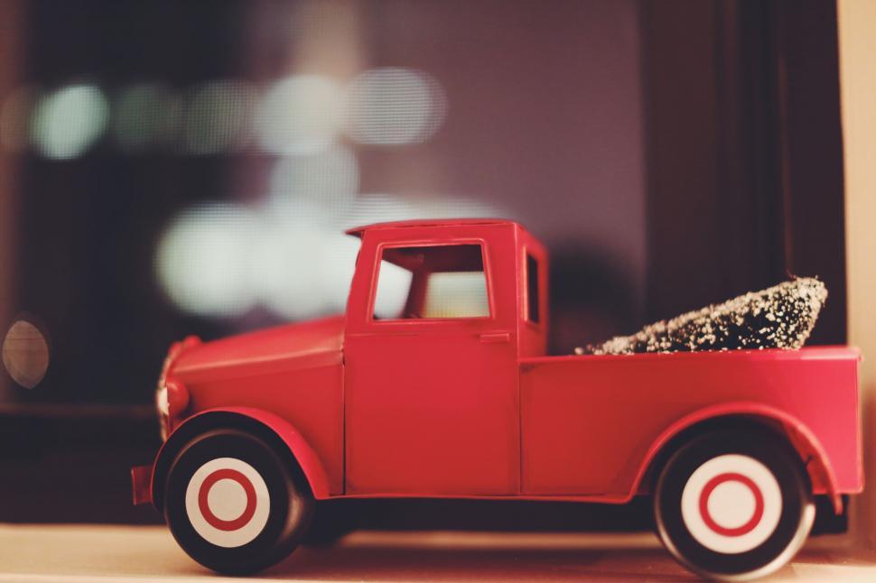 Free Image of Red Toy Truck Transporting Christmas Tree 