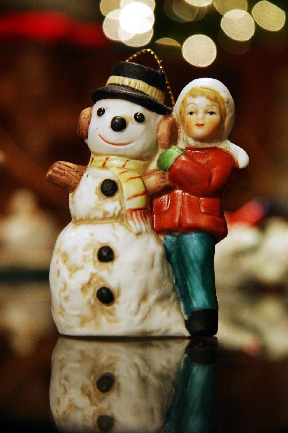 Free Image of Couple Figurines Standing Next to Snowman 