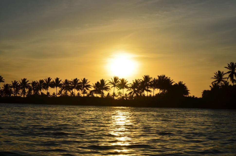 Free Image of The Sun Sets Over a Tropical Island 