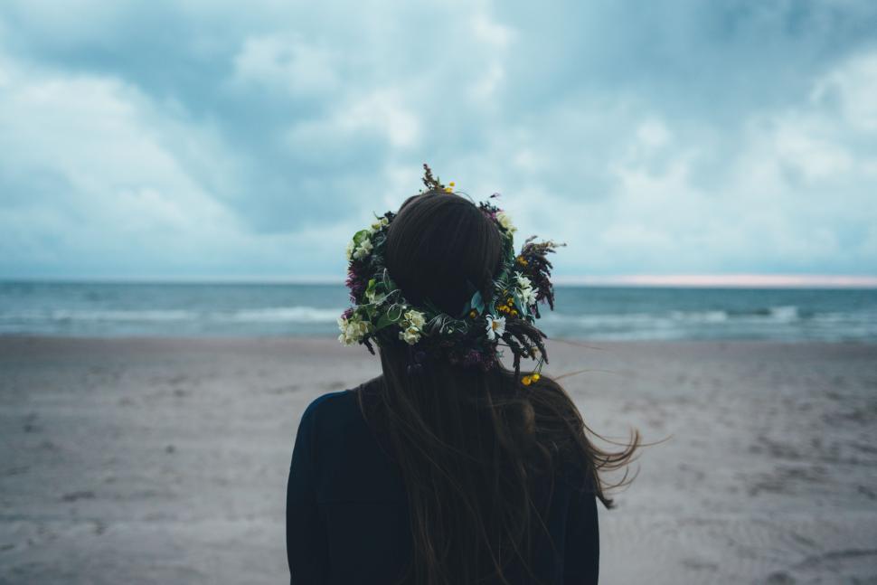 Free Image of Person Standing on Beach With Flower Wreath in Hair 