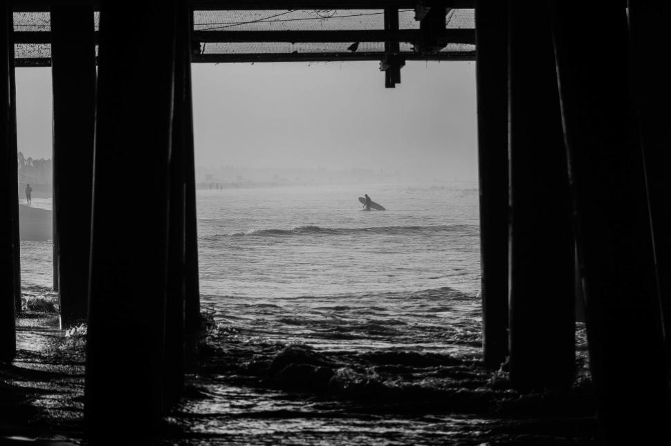 Free Image of Surfing Under a Pier 