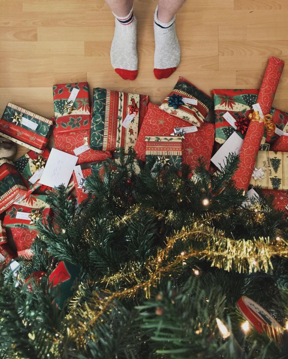 Free Image of Person Standing on Pile of Wrapped Presents 
