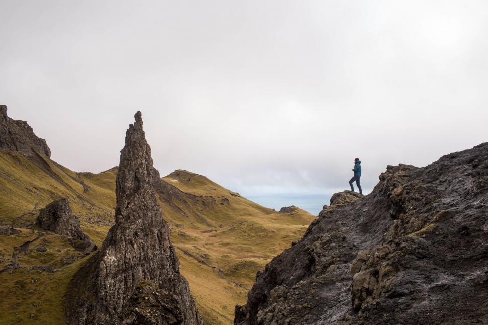 Free Image of Man Standing on Top of Rock Formation 