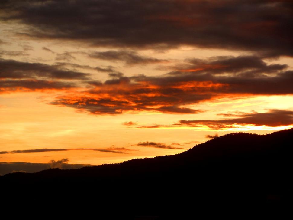 Free Image of sunset sky over silhouetted hills  