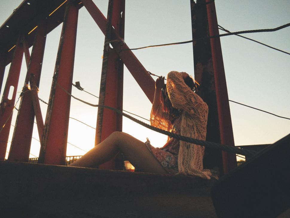 Free Image of Woman sitting on a bridge 