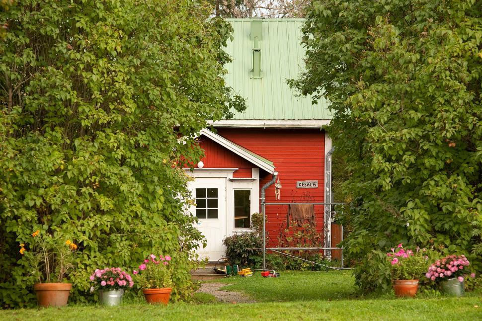 Free Image of Red House Amidst Trees and Flowers 