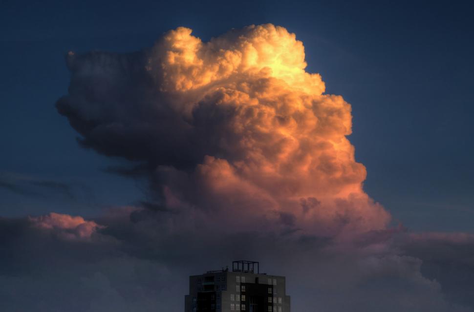 Free Image of Large Cloud Hovering Above Building 