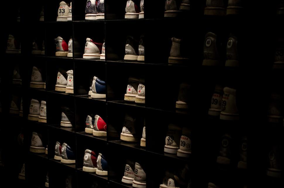 Free Image of Wall of Shoes in Dark Room 
