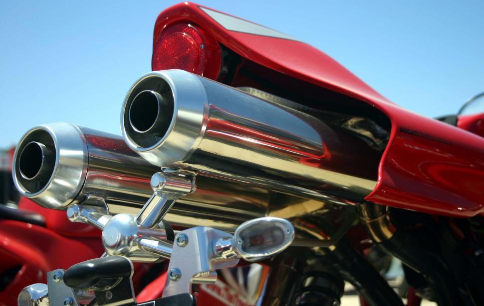 Free Image of Close Up of a Red Motorcycle With Chrome Exhaust Pipes 
