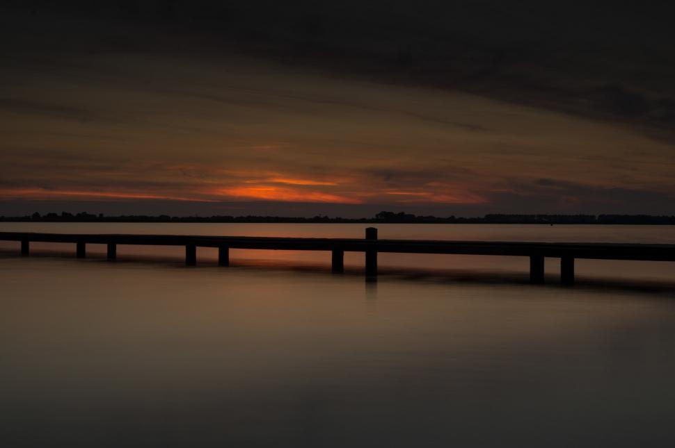 Free Image of The Sun Sets Over a Body of Water 