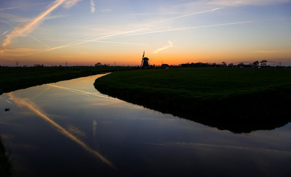 Free Image of Windmill Overlooking Body of Water 