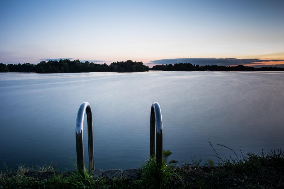 Free Image of Two Metal Railings Overlooking Body of Water 