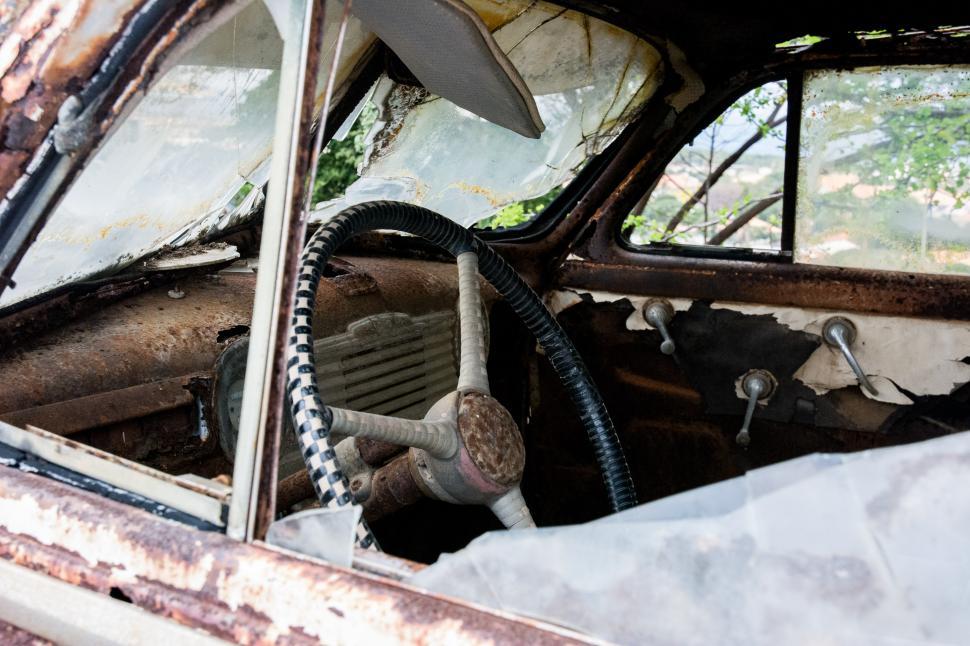 Free Image of Rusted Out Car With Hose Attachment 