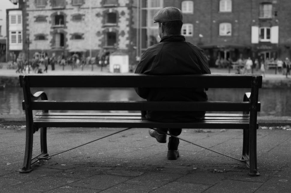 Free Image of Man Sitting on Bench by Waterfront 