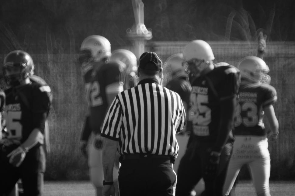 Free Image of Referee Standing Next to Football Player on Field 