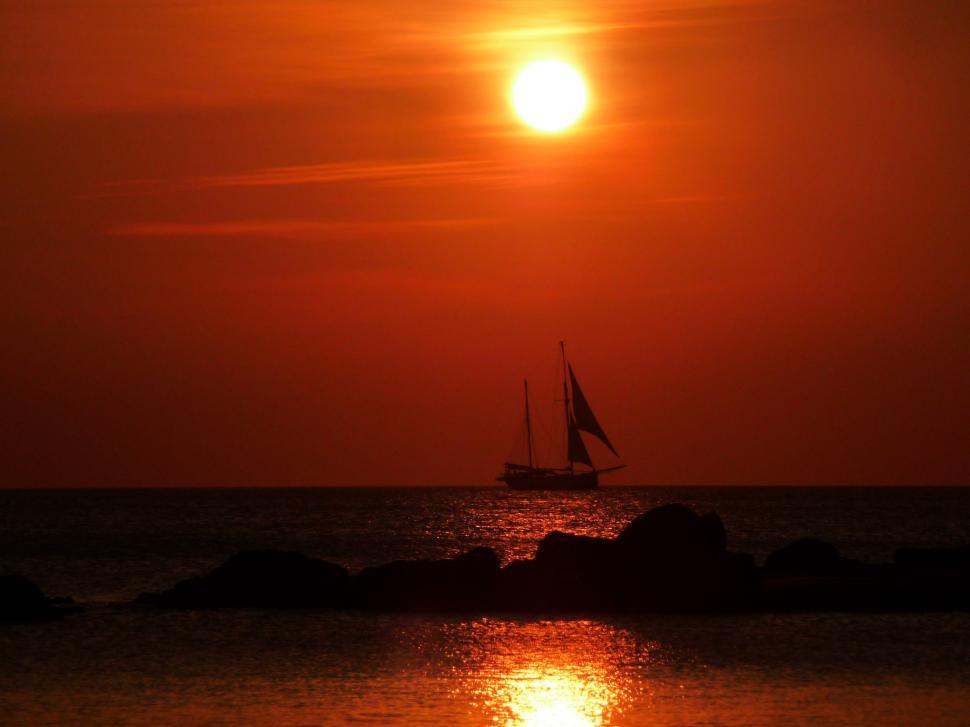 Free Image of Sailboat Sailing in the Ocean at Sunset 