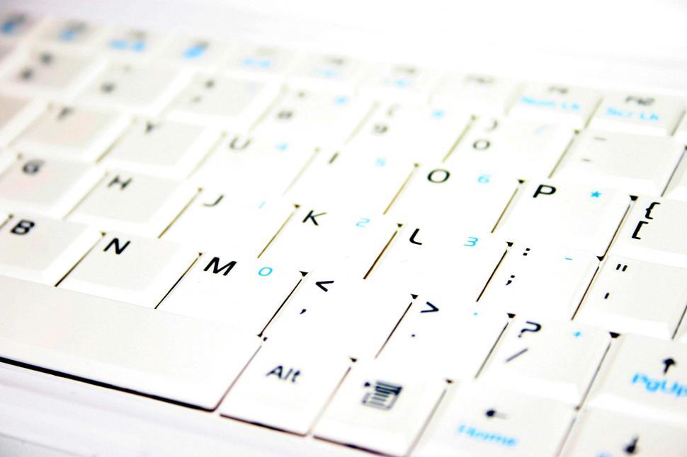 Free Image of Close Up of a White Keyboard With Blue Letters 