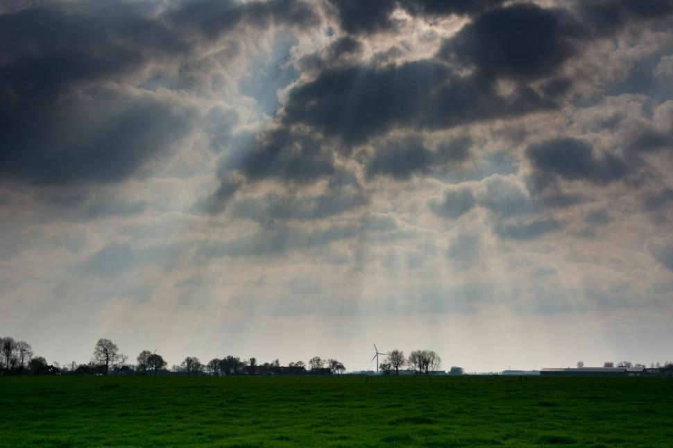 Free Image of Green Field With Cloud-Filled Sky 
