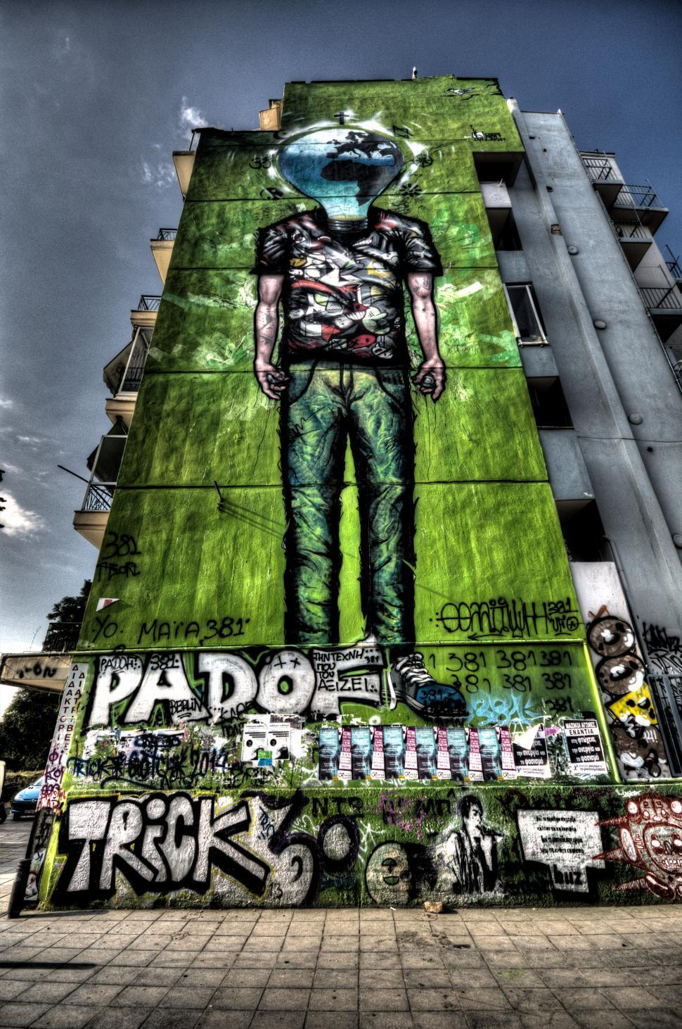 Free Image of Man Standing in Front of Graffiti-Covered Tall Building 