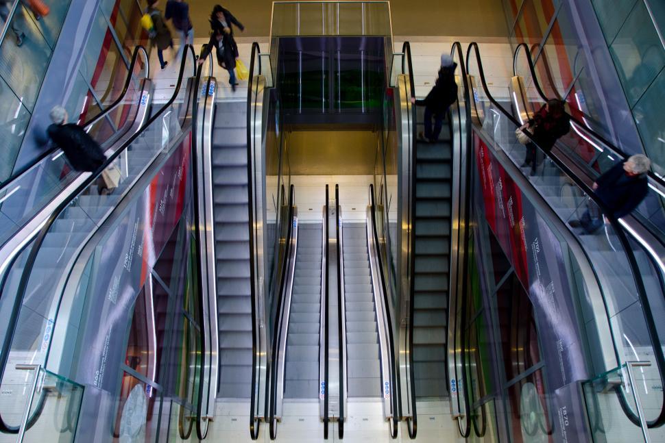 Free Image of Group of People Riding Down an Escalator 
