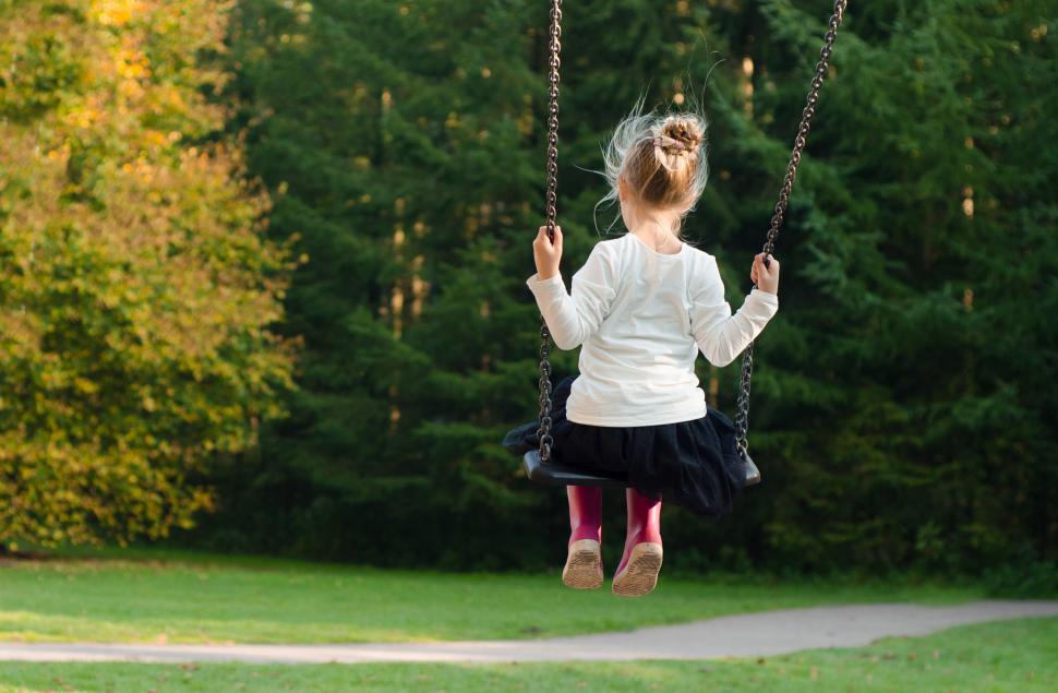 Free Image of Little Girl Swinging on a Swing in a Park 