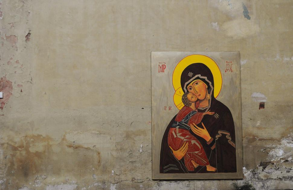 Free Image of Woman Holding Child Painting on Wall 