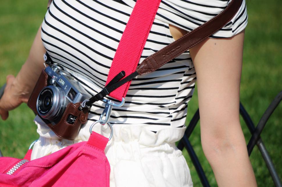 Free Image of Woman Holding Camera and Pink Bag 