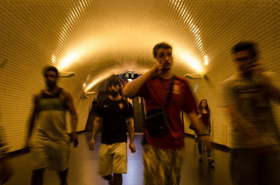 Free Image of Group of People Walking Through a Tunnel 