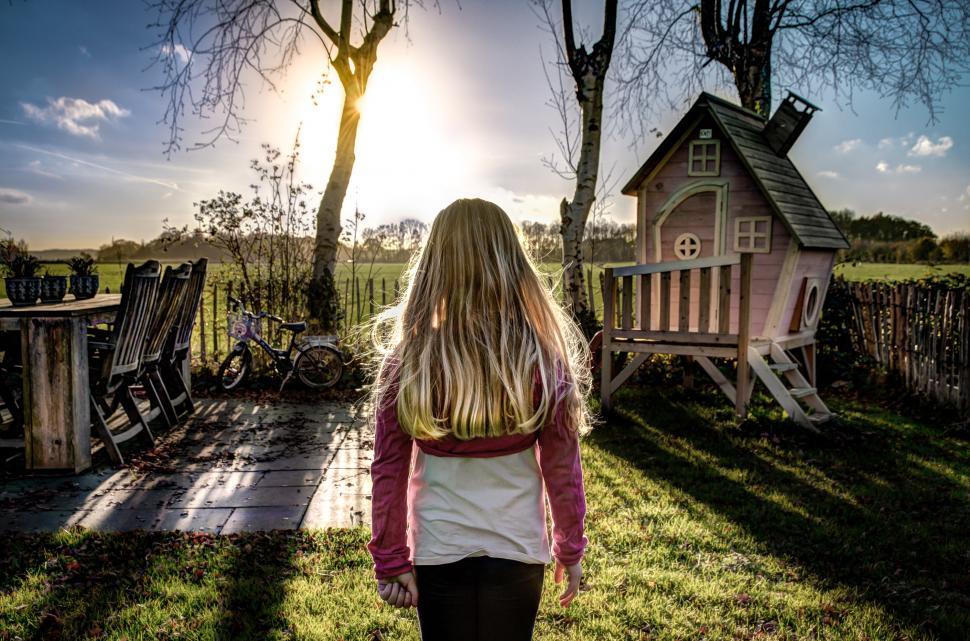 Free Image of Girl Walking Towards Small Wooden House 