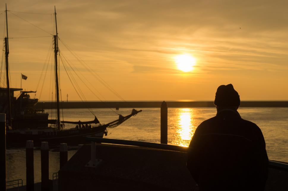 Free Image of Man Observing Water at Sunset 