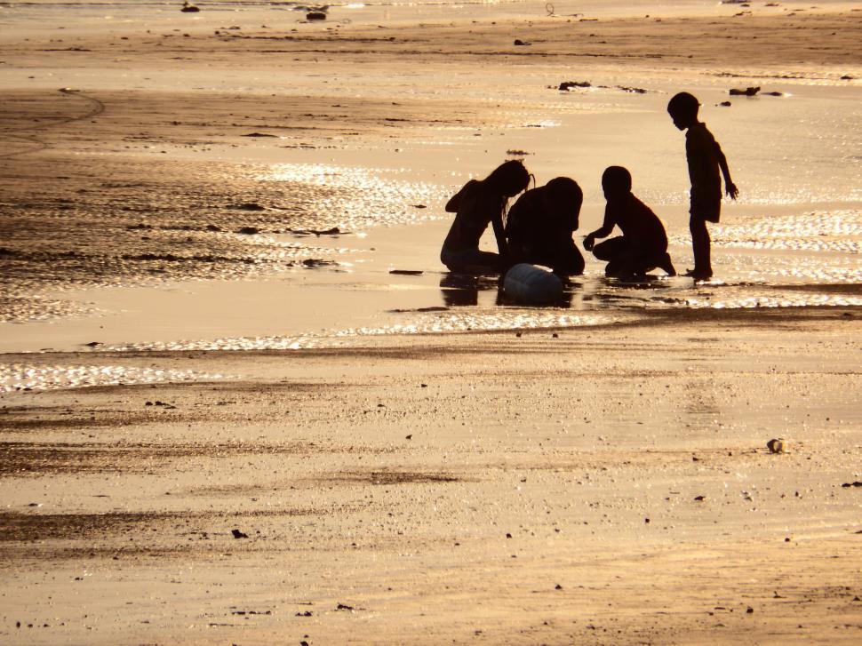 Free Image of Family Plays on the Beach Sand Silhouette  