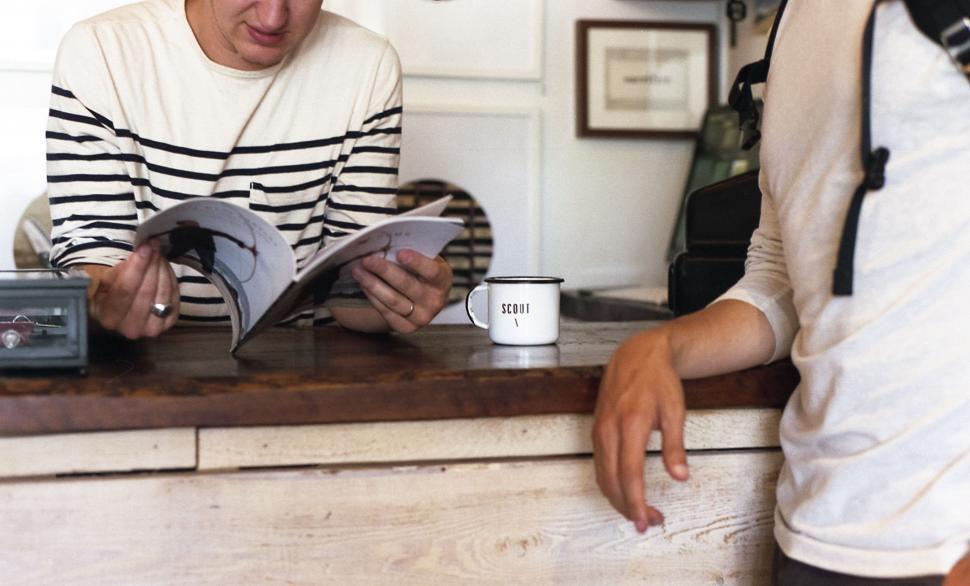 Free Image of Man and Woman Reading Book at Counter 