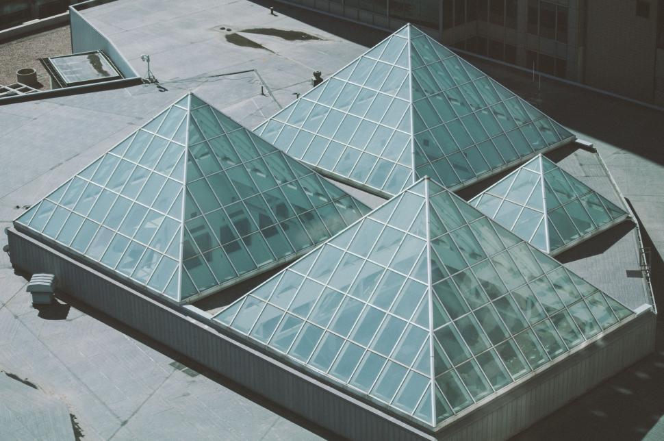 Free Image of Three Pyramids Towering Behind a Building 