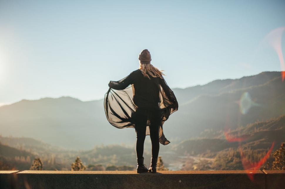 Free Image of Person Standing on Ledge With View of Mountains 