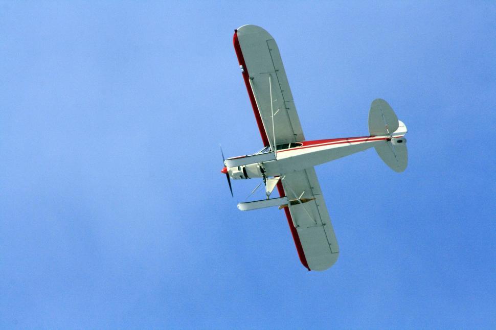 Free Image of Small Airplane Flying Through Blue Sky 