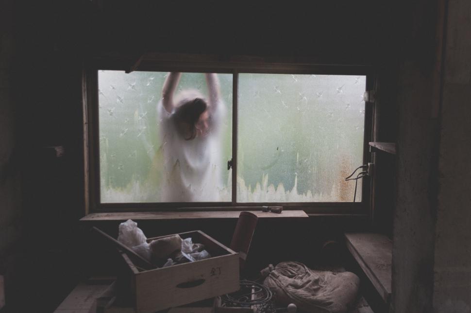 Free Image of Person Standing in Front of Window 