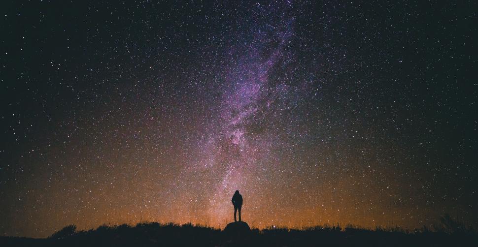 Free Image of Person Standing on Top of Hill Under Night Sky Filled With Stars 