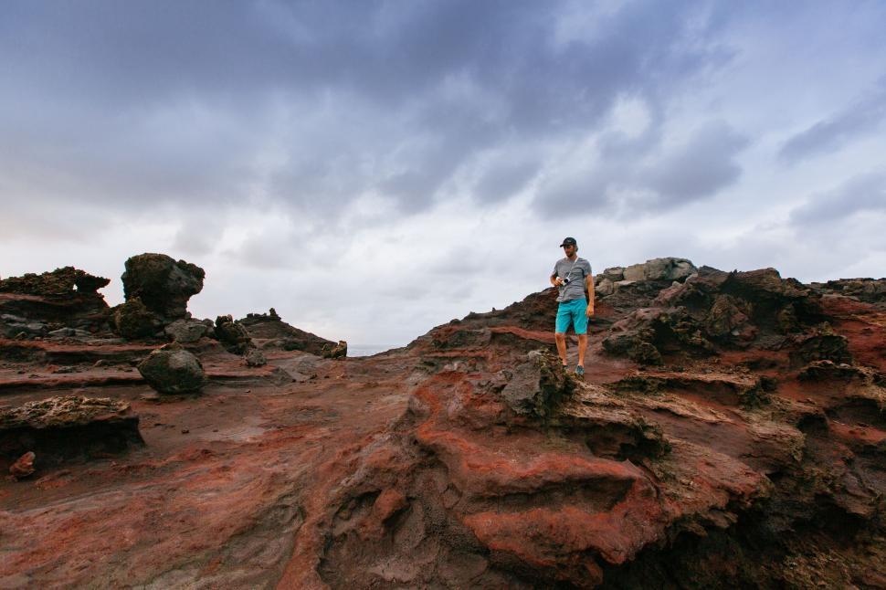 Free Image of Man Standing on Top of Rocky Hill 