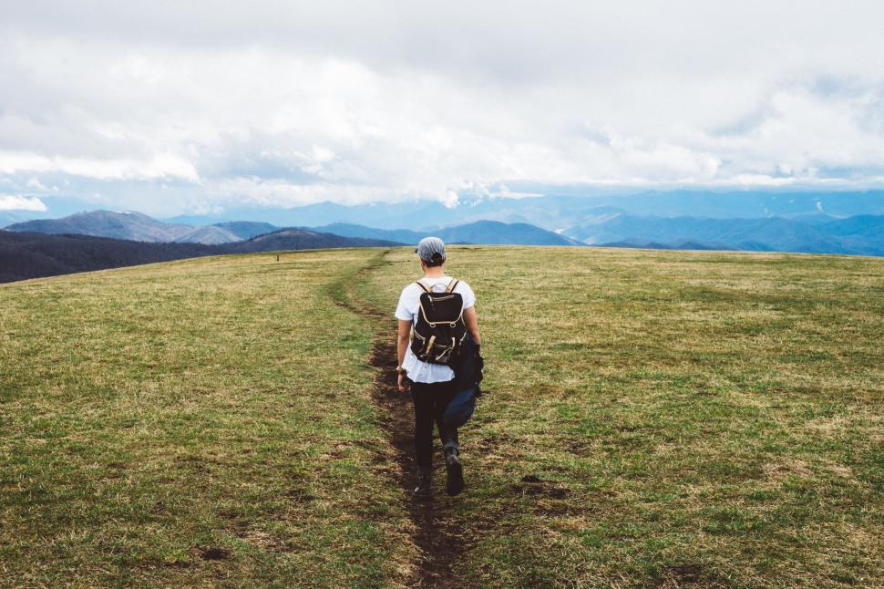 Free Image of Person Walking up a Hill With a Backpack 