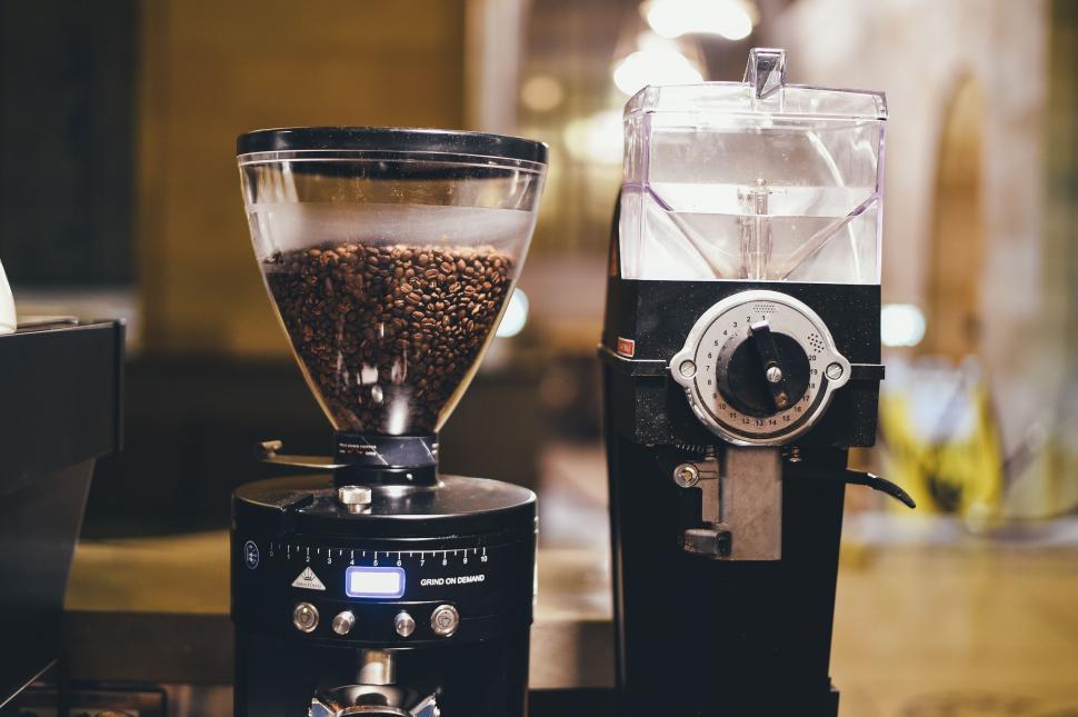Free Image of Coffee Grinder Next to Filled Grinder With Coffee Beans 