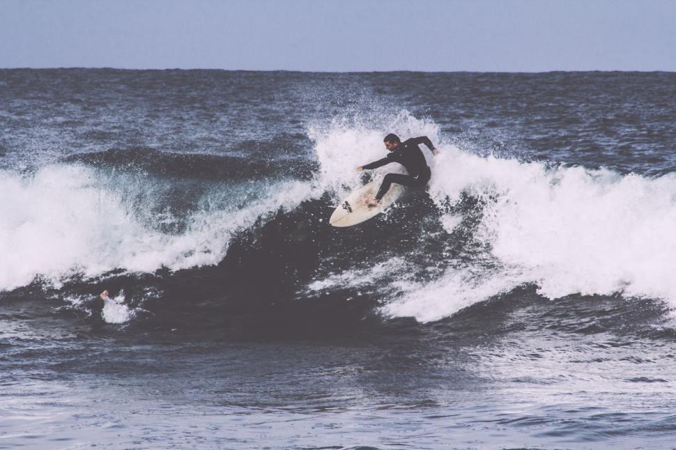 Free Image of Man Riding Wave on Surfboard 